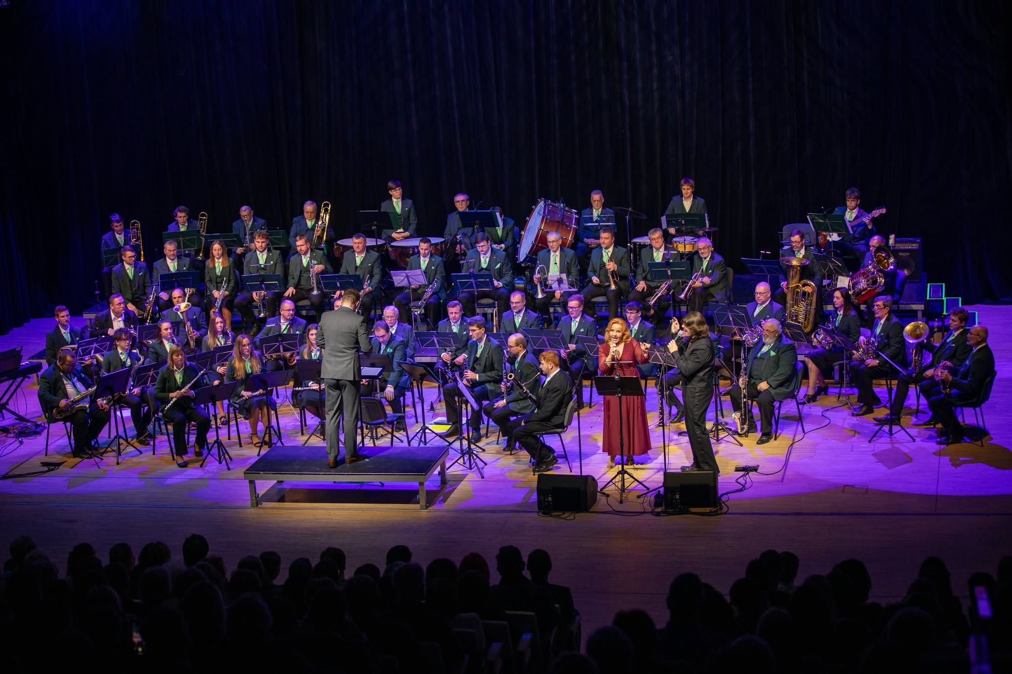 Markéta Amerighi zpívá s Podnikovým dechovým orchestrem Škoda, celý orchestr na jevišti