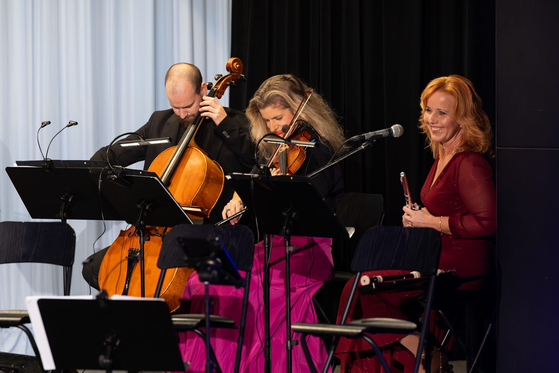 Markéta Amerighi playing the flute in a trio with a cellist and a violinist in Dobrovice